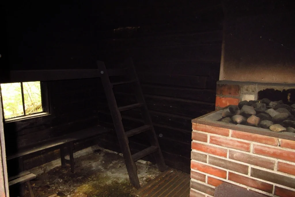 traditional smoke sauna with a large wood-burning stove