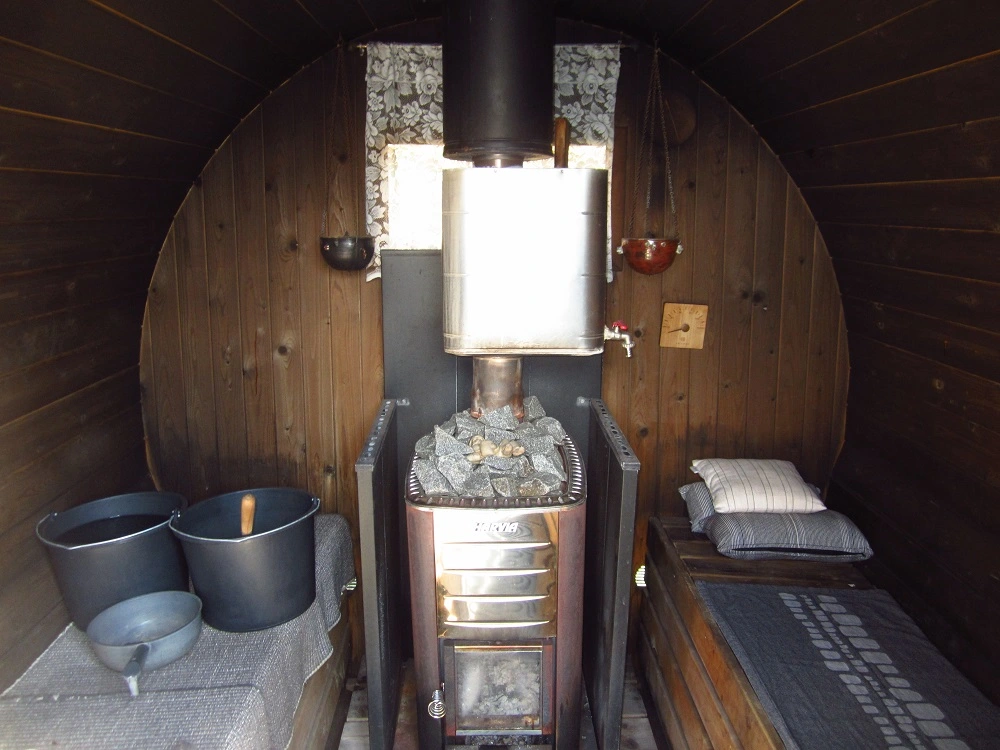 Harvia wood stove and benches in a barrel sauna