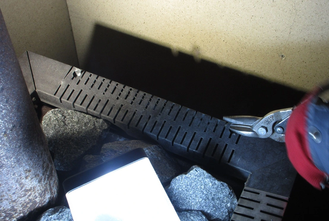 cutting into sauna stove with snips