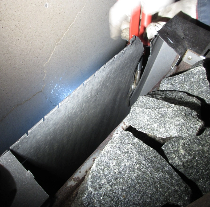 snipping into the side of sauna stove
