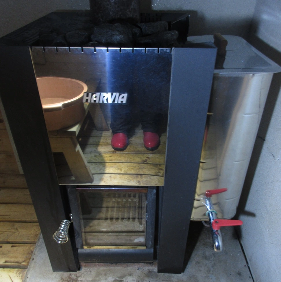 sauna stove and water tank reflecting the floor